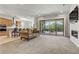 Bright, open-concept living room with fireplace, sliding glass doors, and connection to a modern kitchen at 44 Strada Caruso, Henderson, NV 89011