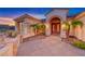 Inviting front entrance featuring desert landscaping, gated front courtyard with palms, and an arched entryway at 1950 Colvin Run Dr, Henderson, NV 89052