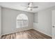 Bedroom with wood-look floors, ceiling fan and arched window at 3125 N Buffalo Dr # 1133, Las Vegas, NV 89128