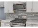 Stainless steel appliances and gray tile backsplash in kitchen at 8774 Libertyvale Dr, Las Vegas, NV 89123