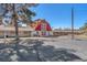 Exterior shot of the white and red barn with a 'Sierra Vista Ranchos' sign, showcasing ample parking space at 2868 Vista Del Sol Ave, Las Vegas, NV 89120