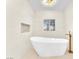 Bright bathroom with a standalone tub, wavy accent wall and modern fixtures at 2868 Vista Del Sol Ave, Las Vegas, NV 89120