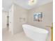 Bright bathroom with a standalone tub, wavy accent wall and modern fixtures at 2868 Vista Del Sol Ave, Las Vegas, NV 89120
