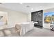 Bright bedroom with a massage table, a black accent wall, and natural light from the window at 2868 Vista Del Sol Ave, Las Vegas, NV 89120