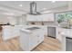 Bright kitchen featuring an island with a cooktop, white cabinets, and modern stainless steel appliances at 2868 Vista Del Sol Ave, Las Vegas, NV 89120