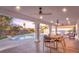 Covered patio featuring ceiling fans, a dining table and backyard pool at 2868 Vista Del Sol Ave, Las Vegas, NV 89120