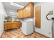 Functional laundry room featuring a washer, dryer, storage cabinets, and tiled flooring at 3841 Hildebrand Ln, Las Vegas, NV 89121