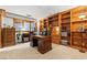 A well-lit home office boasts custom built-in wooden shelves, providing ample storage and organization space at 3841 Hildebrand Ln, Las Vegas, NV 89121