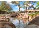 Relaxing backyard pond with rock waterfall and lush landscaping at 3841 Hildebrand Ln, Las Vegas, NV 89121