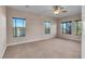 Bright bedroom featuring three windows, ceiling fan and carpet at 2410 Encouraging Ct, Henderson, NV 89052