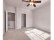 Well-lit bedroom with ceiling fan, carpet, and access to hallway at 2410 Encouraging Ct, Henderson, NV 89052