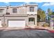 Tan three-story townhome with two-car garage and a red curb at 2410 Encouraging Ct, Henderson, NV 89052