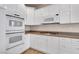 White kitchen with stainless steel appliances and granite countertops at 2410 Encouraging Ct, Henderson, NV 89052