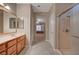 Bright bathroom with a double vanity, glass shower, and entrance to a nearby bedroom at 2820 Goldcreek St, Henderson, NV 89052