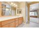 Bathroom featuring wood cabinets, dual sinks and a doorway to the bedroom at 2820 Goldcreek St, Henderson, NV 89052