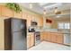 Modern kitchen with sleek stainless steel appliances, natural wood cabinets, and granite countertops at 2820 Goldcreek St, Henderson, NV 89052