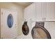 Functional laundry room with white cabinetry and modern washer and dryer at 2820 Goldcreek St, Henderson, NV 89052