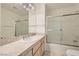 Well-lit bathroom featuring a shower-tub combo with sliding glass doors and an expansive countertop at 3134 Alfa Romero Ave, North Las Vegas, NV 89031