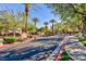 Community entrance with landscaped median and palm trees at 905 Domnus Ln # 101, Las Vegas, NV 89144