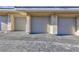 Exterior view of multiple garages with neutral-toned doors and matching architectural details at 905 Domnus Ln # 101, Las Vegas, NV 89144