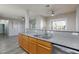 Kitchen with wood cabinets, gray countertops, stainless steel appliances, ceiling fan, and wood floors at 905 Domnus Ln # 101, Las Vegas, NV 89144
