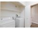 Bright laundry room featuring white washer and dryer and white cabinets and shelves at 905 Domnus Ln # 101, Las Vegas, NV 89144