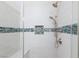 Glass shower featuring white tile and blue accents with dual shower heads at 905 Domnus Ln # 101, Las Vegas, NV 89144