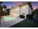 Expansive backyard featuring a swimming pool, golf putting green, and well-manicured landscaping at 605 Canyon Greens Dr, Las Vegas, NV 89144