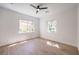 Well-lit bedroom showcasing hardwood floors, recessed lighting, and ample natural light from two windows at 605 Canyon Greens Dr, Las Vegas, NV 89144