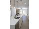 Modern kitchen island with marble countertops, a black faucet, and views of the living area with fireplace at 605 Canyon Greens Dr, Las Vegas, NV 89144