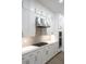 Modern kitchen featuring white cabinetry, marble countertops, stainless steel appliances, and sleek hardware at 605 Canyon Greens Dr, Las Vegas, NV 89144
