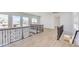 Bright upstairs landing area with wood floors, decorative wrought iron railing, and large windows at 605 Canyon Greens Dr, Las Vegas, NV 89144