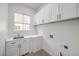 Laundry room featuring white cabinetry, a sink, and a window at 605 Canyon Greens Dr, Las Vegas, NV 89144