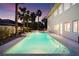 Backyard featuring a rectangular pool, palm trees, and a well-maintained home exterior at 605 Canyon Greens Dr, Las Vegas, NV 89144