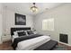Comfortable bedroom features a king bed with dark bedding, minimalist art, and a ceiling fan at 9143 Irish Elk Ave, Las Vegas, NV 89149