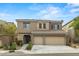 Inviting two-story home showcasing stone accents, a tile roof, and a spacious three-car garage with a well-maintained front yard at 9143 Irish Elk Ave, Las Vegas, NV 89149