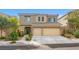 Two-story home with stone accents, desert landscaping, and a two-car garage on a sunny day at 9143 Irish Elk Ave, Las Vegas, NV 89149