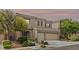 Charming two-story home showcasing stone accents, a well-manicured lawn, and a spacious three-car garage at 9143 Irish Elk Ave, Las Vegas, NV 89149
