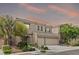 Beautiful two-story home with a stone facade, desert landscaping, and a two-car garage at sunset at 9143 Irish Elk Ave, Las Vegas, NV 89149