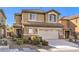 Two-story house with tan exterior, large garage, and landscaping at 315 Foster Springs Rd, Las Vegas, NV 89148