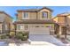 Two-story house with tan exterior, large garage, and landscaping at 315 Foster Springs Rd, Las Vegas, NV 89148