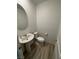 Powder bathroom featuring pedestal sink, toilet, and wood-look flooring at 3245 Montage Dr, Henderson, NV 89044