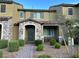 Charming townhome featuring stone accents, covered porch, landscaped yard, and neutral color palette at 3245 Montage Dr, Henderson, NV 89044