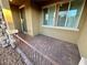 Covered front patio with a decorative brick surface and a view of the entry door and windows at 3245 Montage Dr, Henderson, NV 89044