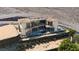 Aerial view of a two-story home with balconies, a pool, and desert landscaping at 4 Olympia Summit Dr, Las Vegas, NV 89141