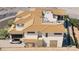 Aerial view of a two-story home with a rooftop deck, two-car garage, and desert landscaping at 4 Olympia Summit Dr, Las Vegas, NV 89141