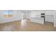 Bright, open-concept with wood floors, a white kitchen, an island, and sliding glass doors at 651 N Water St, Henderson, NV 89015