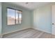 Bedroom with light blue walls, wood-look floors, and a window at 10254 Fairview Ridge Ct, Las Vegas, NV 89166
