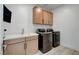 Laundry room with cabinets, sink, and modern washer/dryer at 10254 Fairview Ridge Ct, Las Vegas, NV 89166