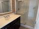 Bathroom featuring walk-in shower with glass door, vanity, and decorative tile at 9092 Iron Cactus Ave, Las Vegas, NV 89148